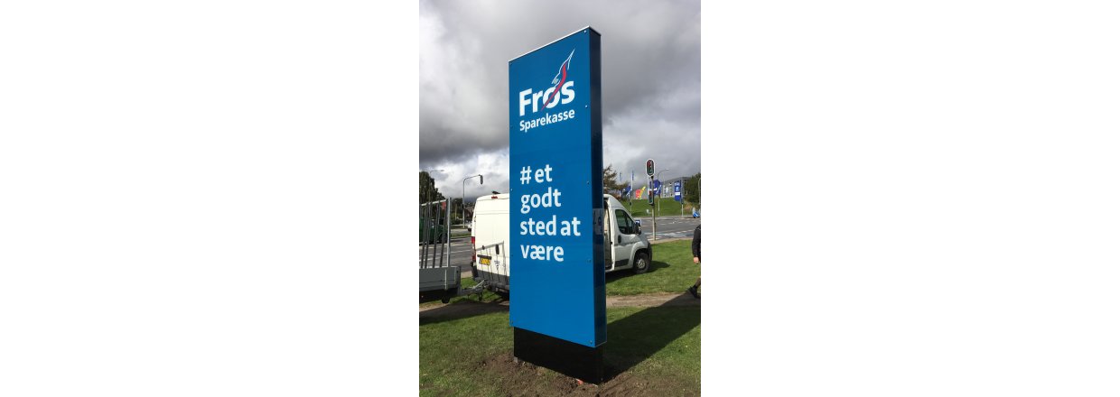 Pylon i glas med indbygget lys, dag.